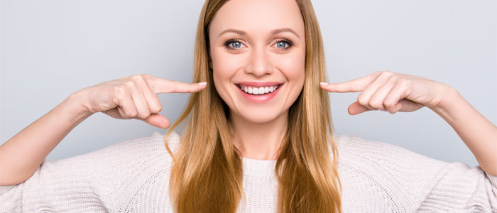 smiling lady pointing at her teeth